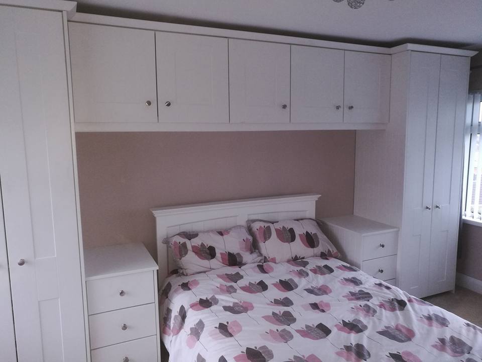 Pink bedroom with white built in wardrobe storage solution